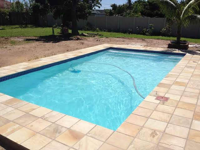 Beautifully tiled swimming pool with non-slip paving and wide steps.